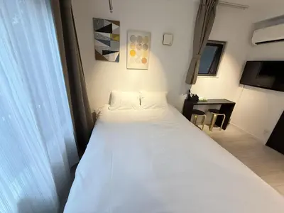 a white bed in a room with a table at NDZ103 3 min walk to station, 2 lines, Yamanote Line, high-speed Wi-Fi in Tokyo