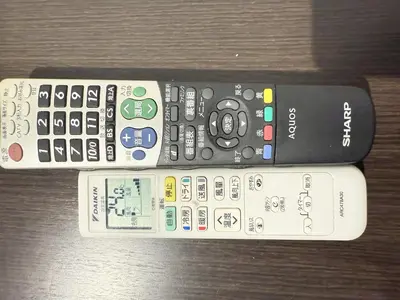 three remote controls sitting next to each other on a table at NDZ103 3 min walk to station, 2 lines, Yamanote Line, high-speed Wi-Fi in Tokyo