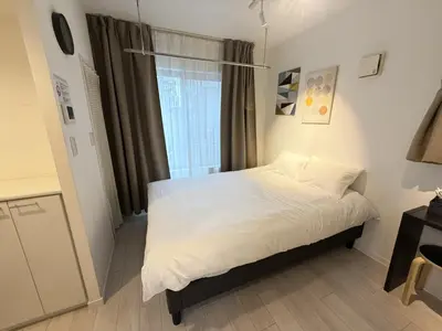 a small bedroom with a white bed and a window at NDZ103 3 min walk to station, 2 lines, Yamanote Line, high-speed Wi-Fi in Tokyo