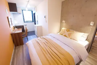a bedroom with a bed and a desk in a room at TOMALCO INN NAKANO 1 4F Flat 2 Bath 13min to Shinjuku from Honancho in Tokyo