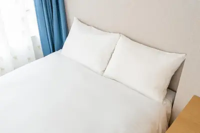 a bed with white pillows sitting next to a window at Humming Kinshicho 303-202-301 - Vacation STAY 19264 in Tokyo