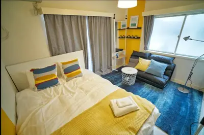 a bedroom with a large bed and a couch at Heights Omiya - Vacation STAY 15175 in Tokyo