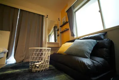 a black leather couch in a room with a window at Heights Omiya - Vacation STAY 15175 in Tokyo