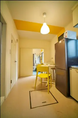 a kitchen with a yellow chair and a refrigerator at Heights Omiya - Vacation STAY 15175 in Tokyo