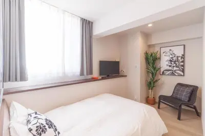 a bedroom with a bed and a chair and a television at LANG HOTEL Kameido - Vacation STAY 79189v in Tokyo