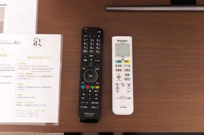 two remote controls sitting on a table next to a receipt at LANG HOTEL Kameido - Vacation STAY 79534v in Tokyo