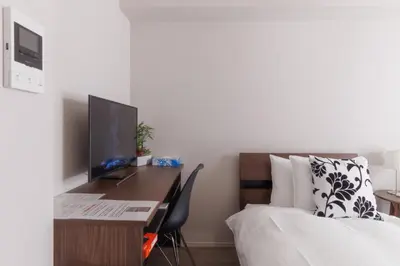 a bedroom with a desk with a computer and a bed at LANG HOTEL Kameido - Vacation STAY 79478v in Tokyo