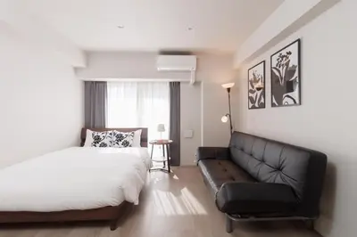 a bedroom with a bed and a couch at LANG HOTEL Kameido - Vacation STAY 79246v in Tokyo