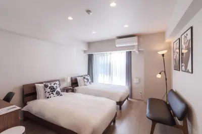a hotel room with two beds and a desk at LANG HOTEL Kameido - Vacation STAY 79388v in Tokyo