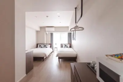a bedroom with two beds and a table in a room at LANG HOTEL Kameido - Vacation STAY 79517v in Tokyo