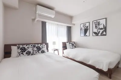 a white bedroom with two beds and a window at LANG HOTEL Kameido - Vacation STAY 79460v in Tokyo