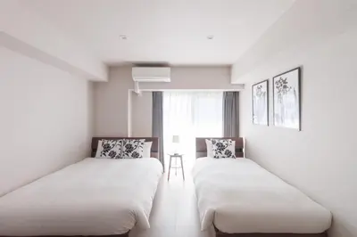 two beds in a room with white walls and a window at LANG HOTEL Kameido - Vacation STAY 79460v in Tokyo