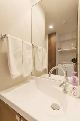 a bathroom with a sink and a mirror and towels at LANG HOTEL Kameido - Vacation STAY 79080v in Tokyo