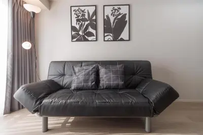 a leather couch in a living room with two pictures on the wall at LANG HOTEL Kameido - Vacation STAY 76836v in Tokyo
