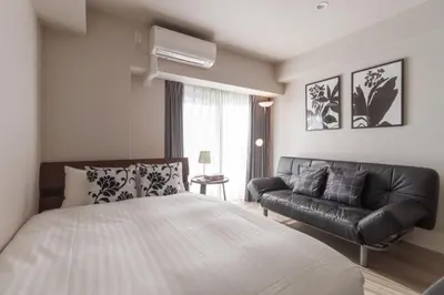 a bedroom with a bed and a couch at LANG HOTEL Kameido - Vacation STAY 79234v in Tokyo