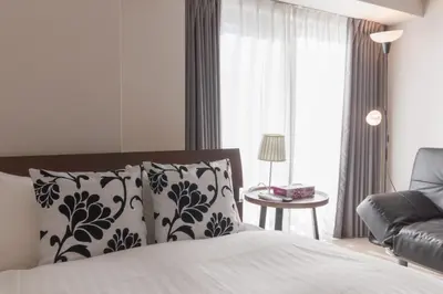 a bedroom with a bed and a couch and a window at LANG HOTEL Kameido - Vacation STAY 79234v in Tokyo