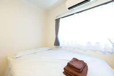 a white bed with a towel on it in front of a window at Kodenmacho Building Room 201 - Vacation STAY 38292v in Tokyo