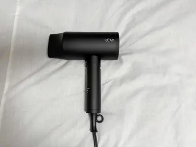 a black hair dryer sitting on top of a bed at Kodenmacho Building Room 201 - Vacation STAY 38292v in Tokyo