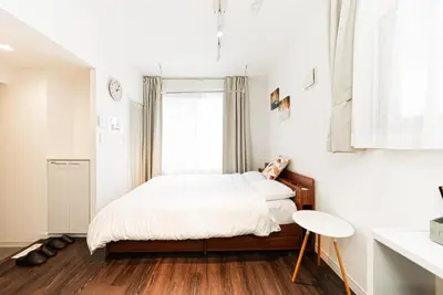 a white bedroom with a bed and a window at NDZ203 3 min walk to station, 2 lines, Yamanote Line, high-speed Wi-Fi in Tokyo