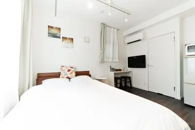a white bedroom with a bed and a tv at NDZ203 3 min walk to station, 2 lines, Yamanote Line, high-speed Wi-Fi in Tokyo