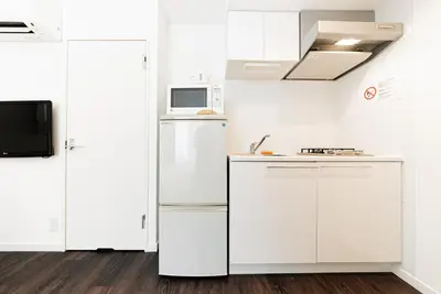 a white kitchen with a refrigerator and a microwave at NDZ203 3 min walk to station, 2 lines, Yamanote Line, high-speed Wi-Fi in Tokyo