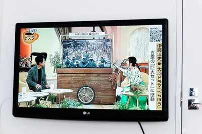 a television with a picture of a man and a woman at NDZ203 3 min walk to station, 2 lines, Yamanote Line, high-speed Wi-Fi in Tokyo