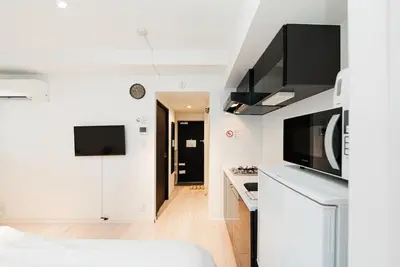 a small white kitchen with a microwave and a counter at NDZ401 3 min walk to station, 2 lines, Yamanote line to Tokyo, high-speed Wi-Fi in Tokyo