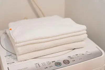 a stack of towels sitting on top of a washing machine at NDZ401 3 min walk to station, 2 lines, Yamanote line to Tokyo, high-speed Wi-Fi in Tokyo