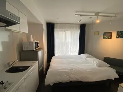 a small bedroom with a bed and a microwave at NDZ401 3 min walk to station, 2 lines, Yamanote line to Tokyo, high-speed Wi-Fi in Tokyo
