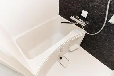 a white bath tub in a bathroom with a hose at NDZ401 3 min walk to station, 2 lines, Yamanote line to Tokyo, high-speed Wi-Fi in Tokyo