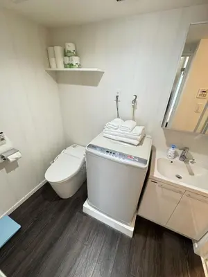 a white bathroom with a toilet and a sink at NDZ403 3 min walk to station, 2 lines, Yamanote line to explore Tokyo, high-speed Wi-Fi in Tokyo