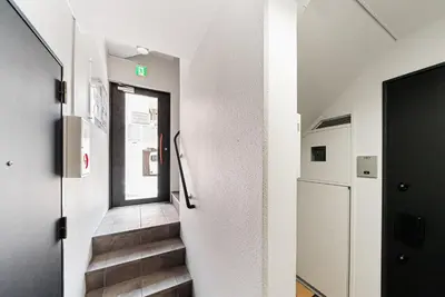 a hallway with a door and stairs in a building at NDZ403 3 min walk to station, 2 lines, Yamanote line to explore Tokyo, high-speed Wi-Fi in Tokyo