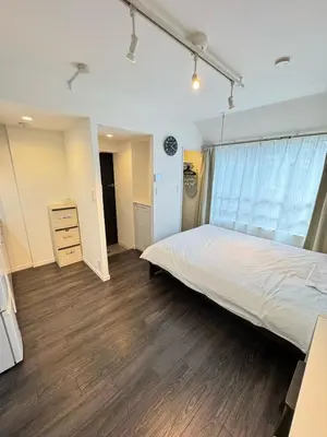 a bedroom with a large white bed and wooden floors at NDZ403 3 min walk to station, 2 lines, Yamanote line to explore Tokyo, high-speed Wi-Fi in Tokyo