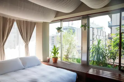 a bedroom with a white bed and large windows at SOIL Nihonbashi Hotel in Tokyo