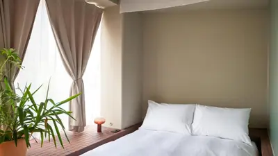 a bedroom with a bed and a large window at SOIL Nihonbashi Hotel in Tokyo