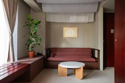 a living room with a red couch and a table at SOIL Nihonbashi Hotel in Tokyo