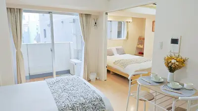 a small room with a bed and a table and chairs at \u9326\u7cf8\u753a\u30fc804 in Tokyo
