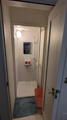 a small bathroom with a shower and a mirror at Tokyo Skytree Tower - Asakusa Auberge de Jeunesse in Tokyo