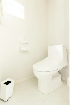 a white bathroom with a toilet and a trash can at Near Shinjuku 3 stops in Tokyo