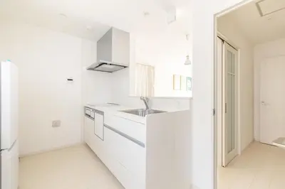 a white kitchen with white cabinets and a sink at Near Shinjuku 3 stops in Tokyo