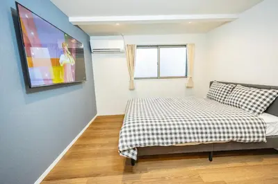a bedroom with a bed and a tv on the wall at Hiro Yanaka hotel TT0421 in Tokyo