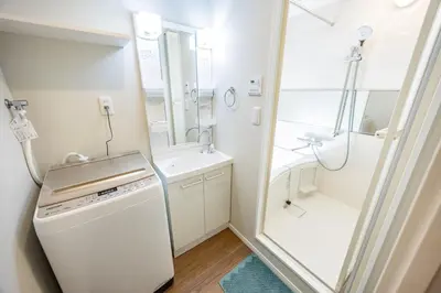 a white bathroom with a shower and a sink at Hiro Yanaka hotel TT0421 in Tokyo