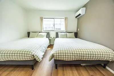 two beds in a small room with a window at Hiro Yanaka hotel TT0421 in Tokyo