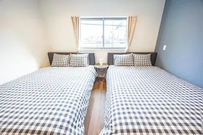 two beds in a small room with a window at Hiro Yanaka hotel TT0421 in Tokyo
