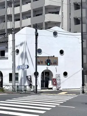a white building with a green traffic light on a street at \u671d\u65e5\u8857\u306e\u5bbf An inn on Asahi Street in Tokyo