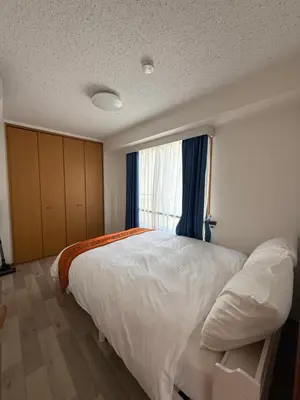 a bedroom with a large white bed and a window at \u671d\u65e5\u8857\u306e\u5bbf An inn on Asahi Street in Tokyo