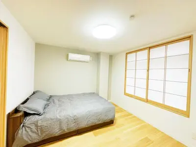 a bedroom with a bed and a large window at \u6587\u4eachouse 202 in Tokyo