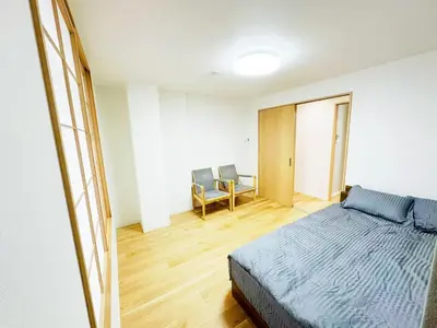 a bedroom with a bed and two chairs in it at \u6587\u4eachouse 202 in Tokyo