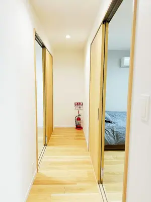 a hallway with two mirrors and a bed in a room at \u6587\u4eachouse 202 in Tokyo