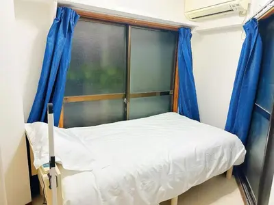 a small bed in a room with a window at \u6587\u4eachouse103 in Tokyo